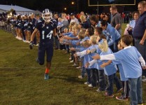 MDFB football player Nick Hitpas gives high fives to several Little Knights and Little Ladies as he makes his run through the pregame tunnel. LKLL members were special guests at the football game on September 28.
