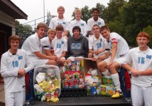 Senior Soccer Knights (sitting below) Evan Ratermann, Dawson Huelskamp, Adam Etter, Max Etter, Jeffrey Wuebbles, David Stevenson, Addison Hustedde, Matt Thompson, (sitting above) Adam Richter, Jordan Becker, and Jalen Albers pack the canned goods collected at home games for distribution to the St. Vincent de Paul Society. The Soccer Knights chose the food collection for their service project.