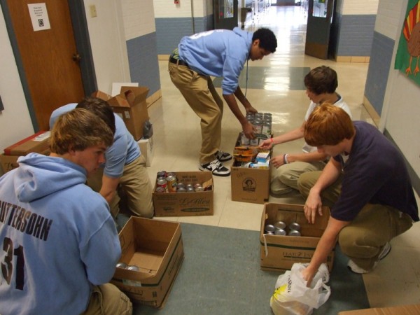 Several members of the packing crew, including (left to right) Justin Guttersohn, Patric Ripperda (hidden), Jalen Albers, Andrew Niemann, and Jon-Erik Kampwerth fill boxes with canned goods collected in the Holiday Food Drive. A total of 1,436 canned food items were collected for this year's drive.